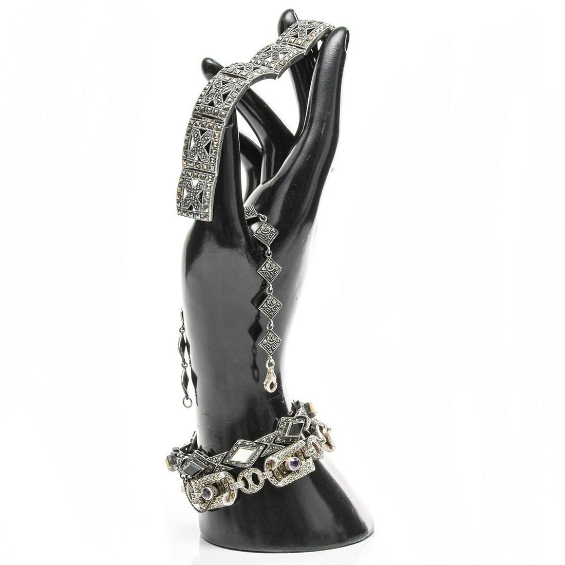 4 STERLING SILVER AND MARCASITE ART DECO BRACELETS: Each stamped 925. Inset amethyst, onyx, and mother of pearl. Total weight is approximately 116g. Issued: 20th c. Dimensions: 7.5"L, longest Provenance: David Farin Collection