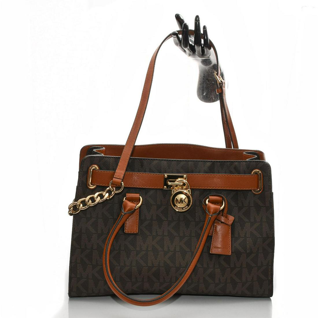 MICHAEL KORS HAMILTON EAST WEST BROWN LEATHER SATCHEL: Signature logo top handle crossbody with additional strap. Michael Kors Hamilton East/West style leather handbag in the brown monogrammed signature pattern and gold hardware. Three large internal comp
