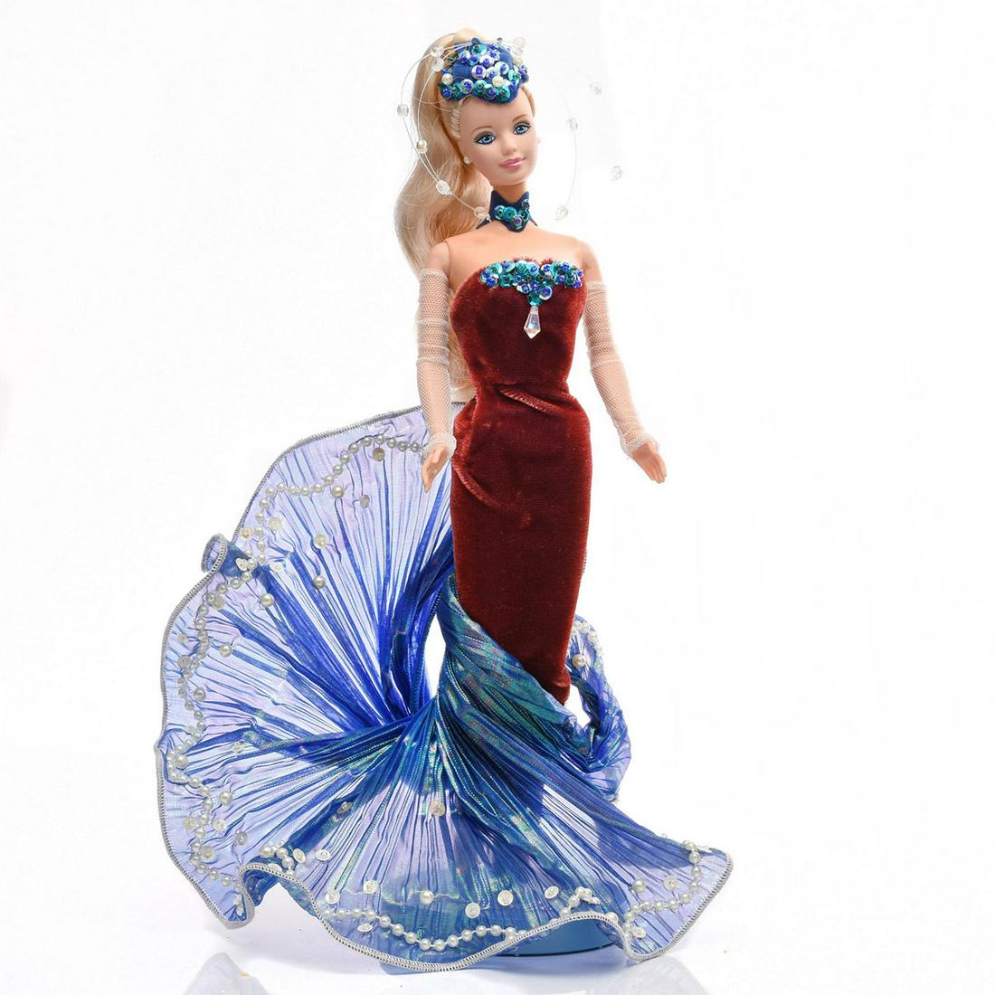 BARBIE COLLECTIBLES, WATER RHAPSODY BARBIE: Burgundy velvet dress with blue taffeta mermaid extension. Her headdress, choker and front top decoration of blue sequins. The blue taffeta mermaid tail is decorated with imitation pearls and sequins.