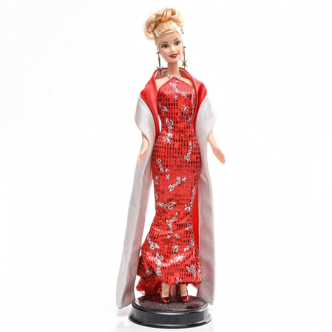 MATTEL BARBIE DOLL, YEAR 2000: Collectors edition, celebrates the year 2000 in grand style. Includes stand. Without original box. Issued: 2000 Dimensions: 12.25"H Manufacturer: Mattel Country of Origin: USA