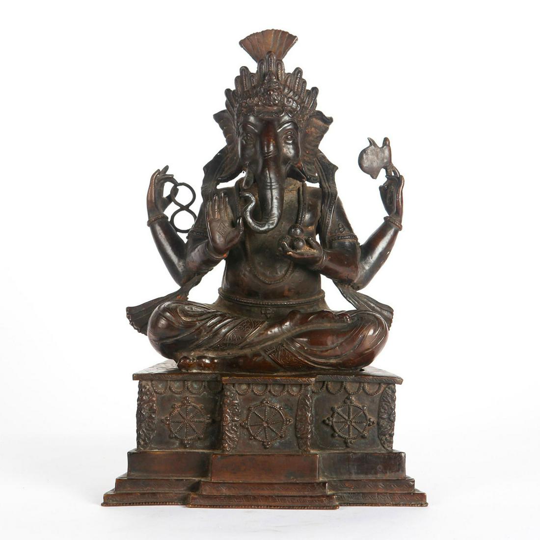 LARGE BRONZE GANESHA STATUE SITTING IN FULL LOTUS: Four armed Ganesha holding axe, sweets, other allegorical motifs. From the James and Marilyn Alsdorf Collection. Total weight 22.5 lbs. Issued: 1900 c. Dimensions: 18.5"H x 12"W x 8"D Country of Origi