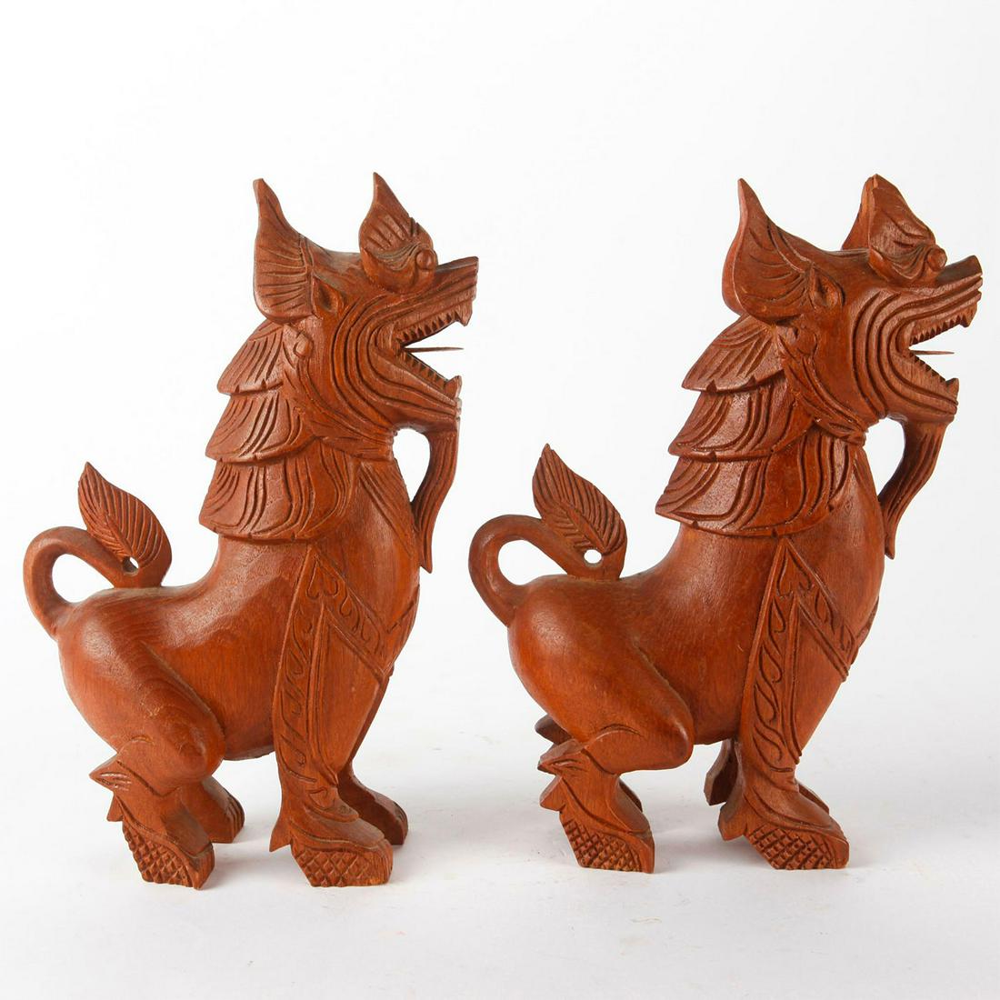 PAIR OF CARVED WOOD CHINESE FOO DOG STATUES: Hand carved wooden stylized mythical guardian lions. These pieces are usually found in front of temples and imperial places. Issued: 20th c. Dimensions: 10.75"H x 7.75"W Country of Origin: China Prove