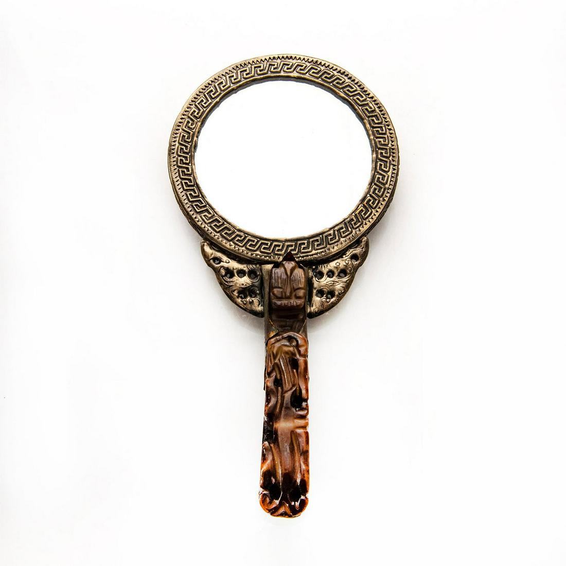 LARGE HAND CARVED STONE BUCKLE CHINESE HAND MIRROR: Figural dragon handle, metal w. dragon relief, cabochons. Issued: 20th c. Dimensions: 9"L x 4.5"W Country of Origin: China Provenance: David Farin Collection