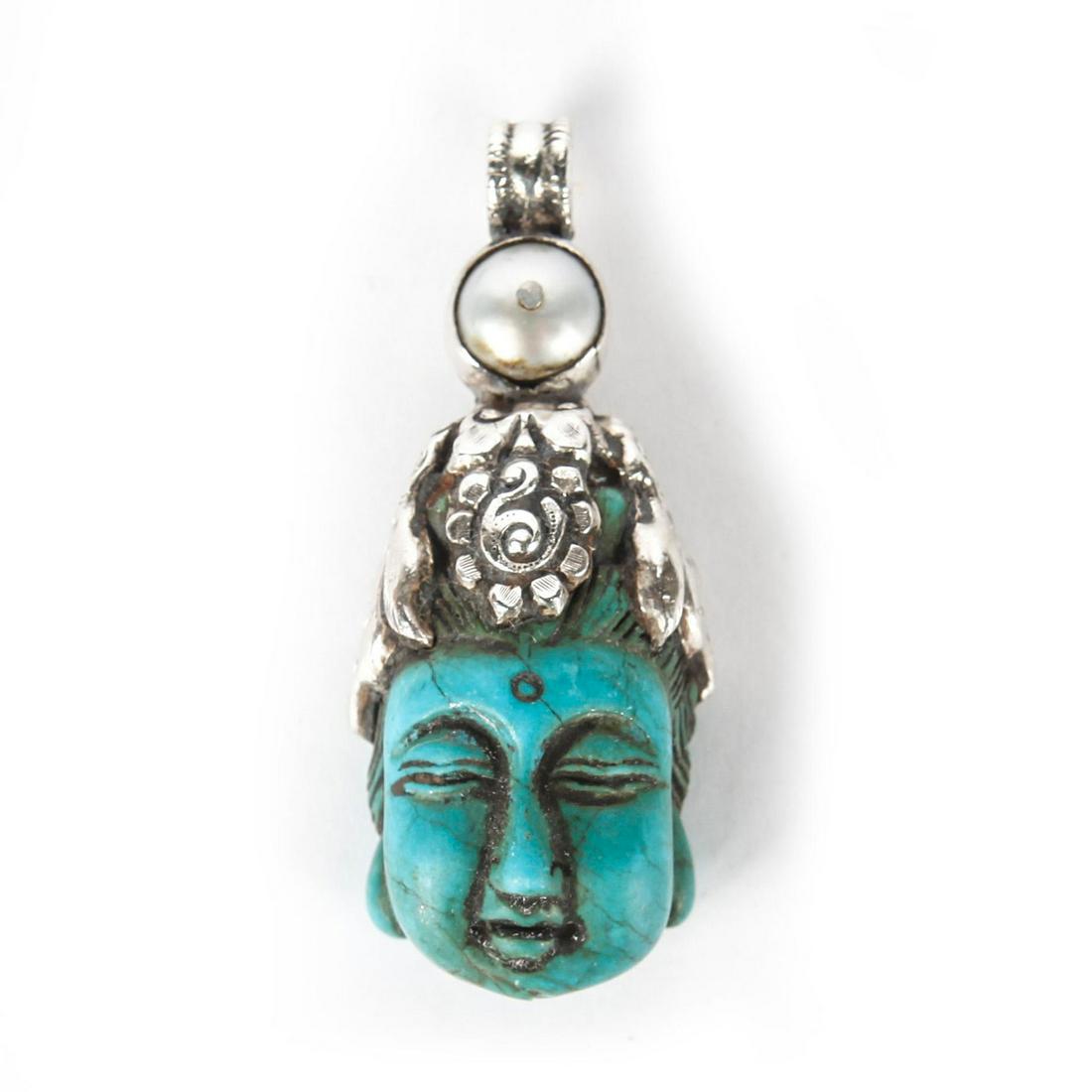 CARVED TURQUOISE BUDDHA PENDANT W. SILVER AND PEARL: Single large turquoise stone, ornate silver detail. Issued: 20th c. Dimensions: 2.5"H Provenance: David Farin Collection