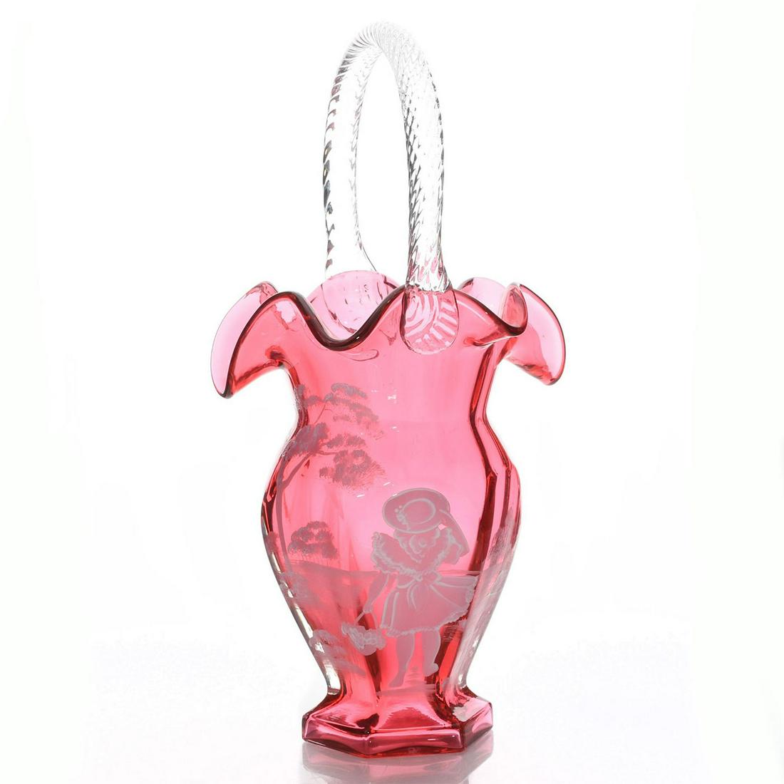 FENTON GLASS BASKET VASE, CRANBERRY MARY GREGORY STYLE: Hand painted white on ruby glass vase, girl with hat. A girl stands with her back in view holding a basket. Issued: 20th c. Dimensions: 11.5"H Manufacturer: Fenton Art Glass Co. Country of Origin: Uni