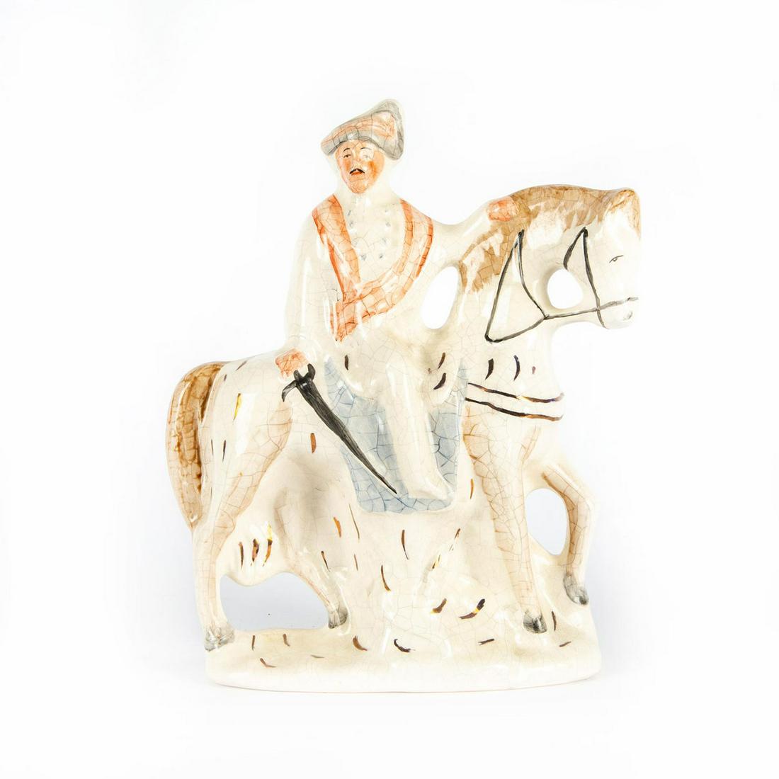STAFFORDSHIRE LARGE FIGURE MAN ON HORSEBACK: Handpainted. Depicts an Arabian knight with sword. Accented with gilt. Desired crazing effect throughout. No markings to bottom base. Issued: 20th c. Dimensions: 14.25"H x13"L