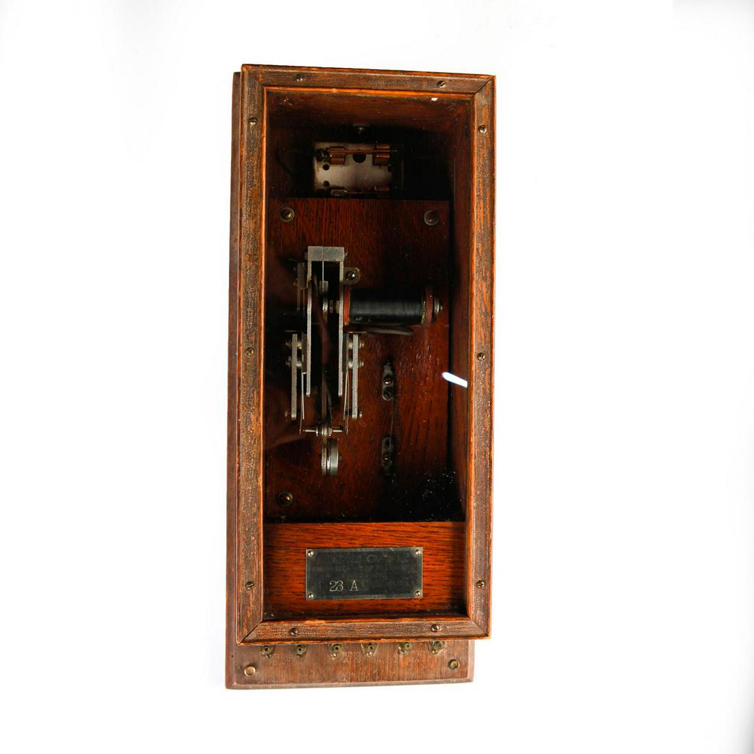 19TH CENTURY KELLOGG TELEPHONE SWITCHER, WOODEN CABINET: Large glass window, brass & metal elements. Manufacturer tag. An antique 19th century telephone switching relay by Kellogg Switchboard of Chicago. Original seven terminal heavy wooden cabinet, each wi