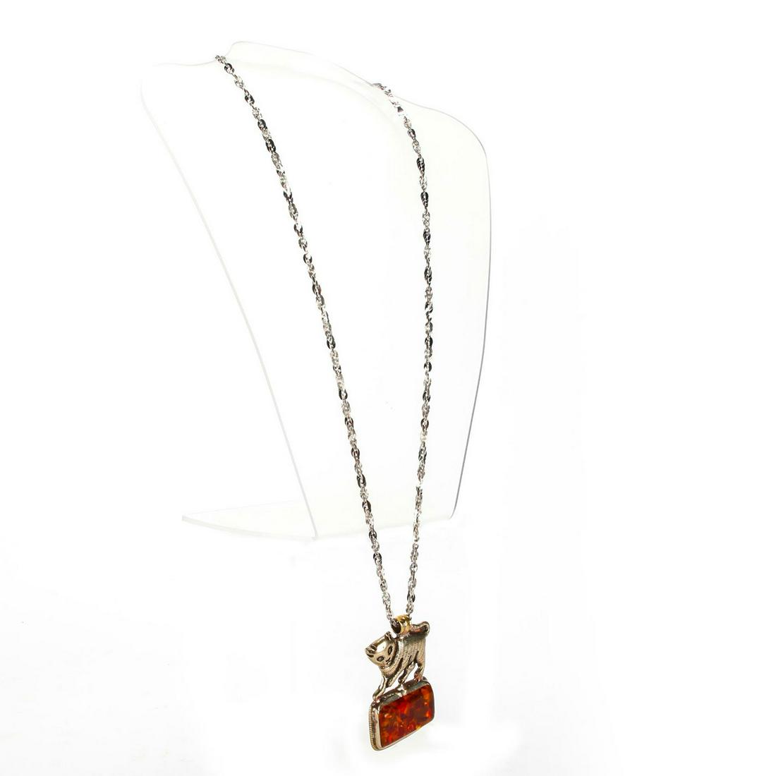 TIBETAN SILVER, AMBER PENDANT W. CAT DESIGN: Fawn, frog, foliate design to back of pendant. Chain marked 925 Italy. Total weight is approximately 58.2g. Issued: 20th c. Dimensions: 30"L Country of Origin: Tibet