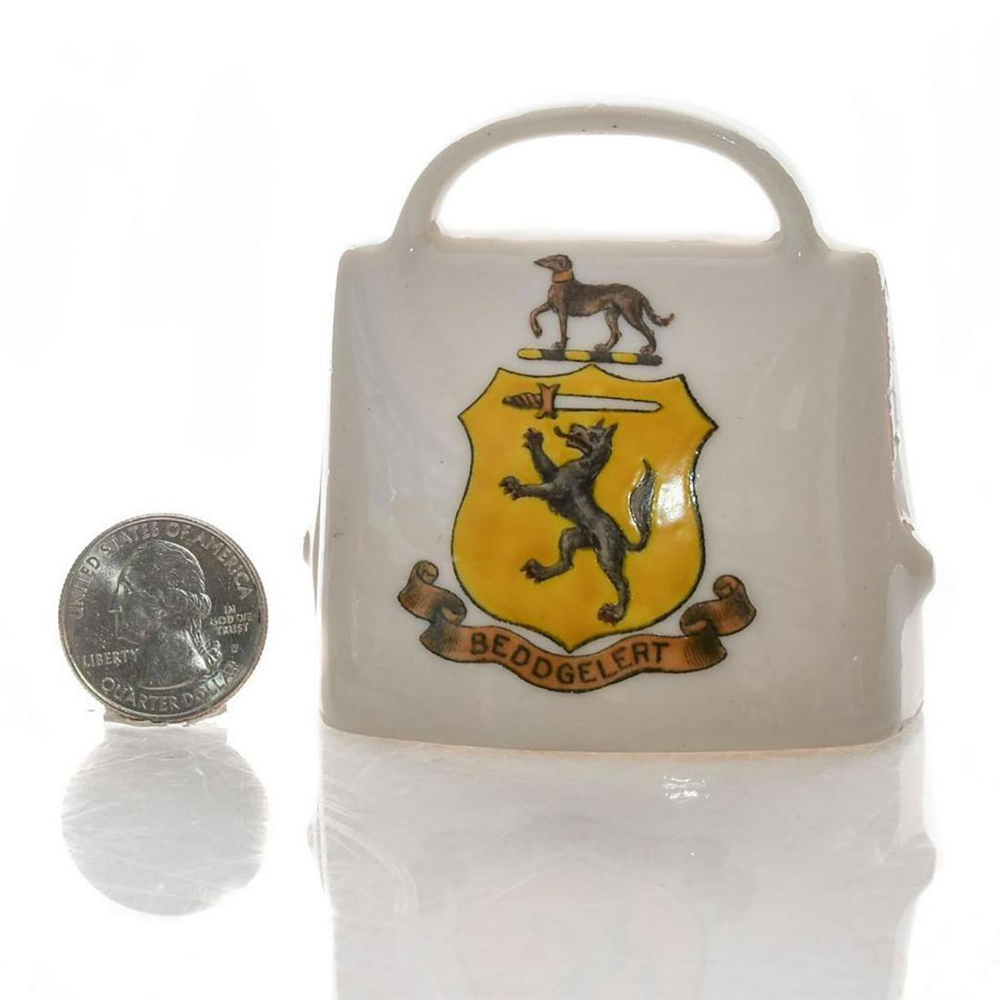 GOSS CRESTED HERALDIC CHINA WALL COW BELL, BEDDGELERT: Glazed white china cowbell with handle. Beddgelert Wales coat of arms on the front. MODEL OF OLD SWISS COW BELL and W.H. Goss stamp inside. Dimensions: 3"H Manufacturer: W.H. Goss Country of Origin: E