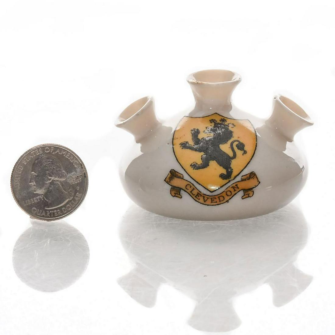 GRAFTON CRESTED HERALDIC CHINA TEAR BOTTLE, CLEVEDON: Glazed white china Egyptian tear bottle. Clevedon coat of arms on front. MODEL OF ANCIENT EGYPTIAN TEAR BOTTLE and Carlton China stamp on bottom. Dimensions: 1.75"H Manufacturer: Grafton China Country