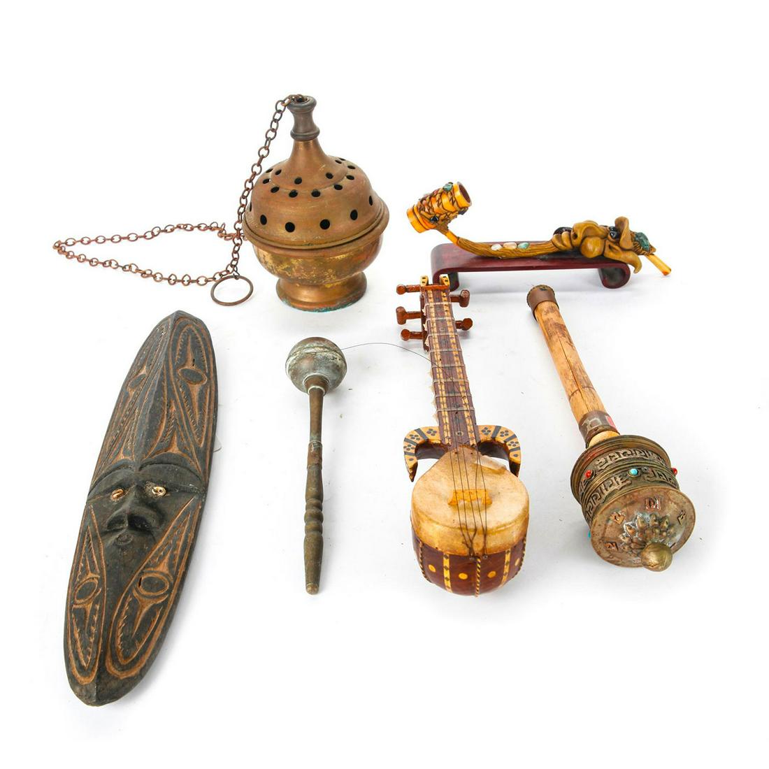 GROUP OF TRIBAL ART PIECES: Varies in type, size, and materials. 1 is carved wood tribal mask. 1 bamboo and pottery pipe with jade stone. A brass incent burner. A painted wood miniature instrument. A bamboo and silver brass nois