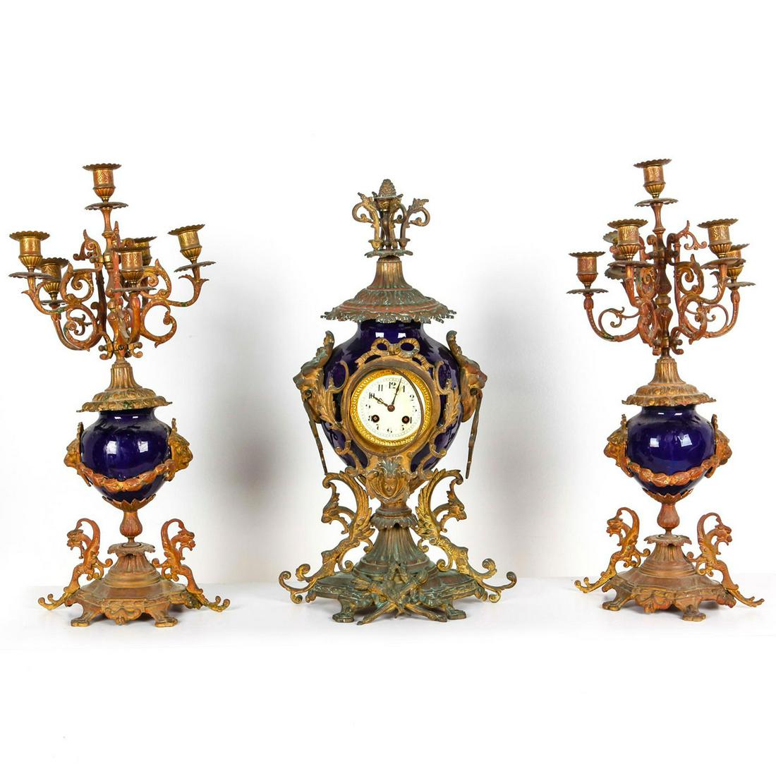 BRONZE AND CERAMIC CLOCK, CANDELABRA GARNITURE SET: European style, blue ceramic w. patina to bronze. Candelabras and clock show age and use related wear, have imperfections to bronze including bent pieces. Clock mechanism is untested. Issued: 20th c.