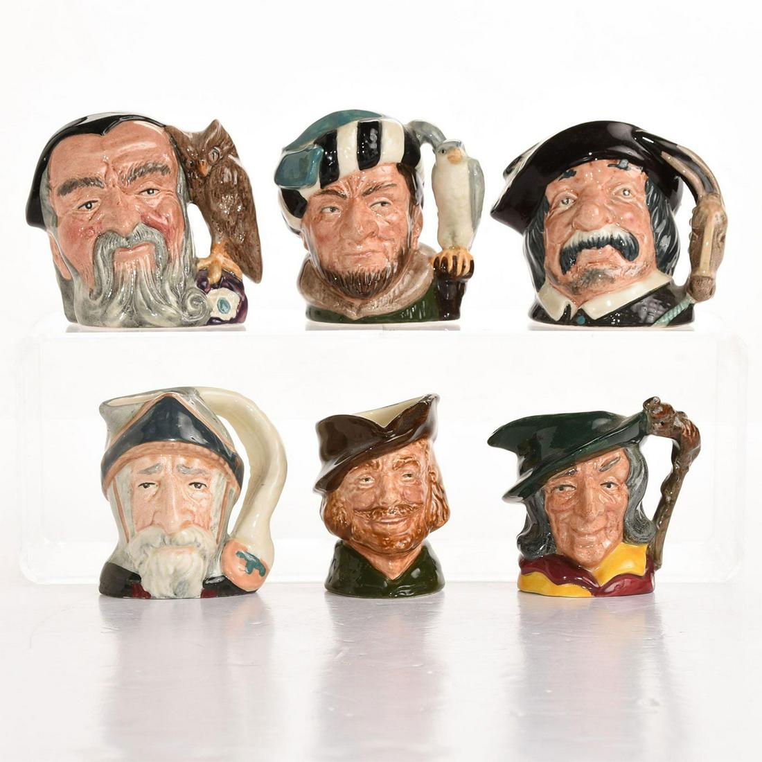 6 ROYAL DOULTON MINIATURE CHARACTER JUGS: Glazed ceramic stoneware, various artists and colorways. Merlin, Robin Hood, Pied Piper, Don Quixote, Sancho Panza, Falconer. Artist: Max Henk, Harry Fenton, Geoff Blower, Issued: 20th c. Dimensions: 