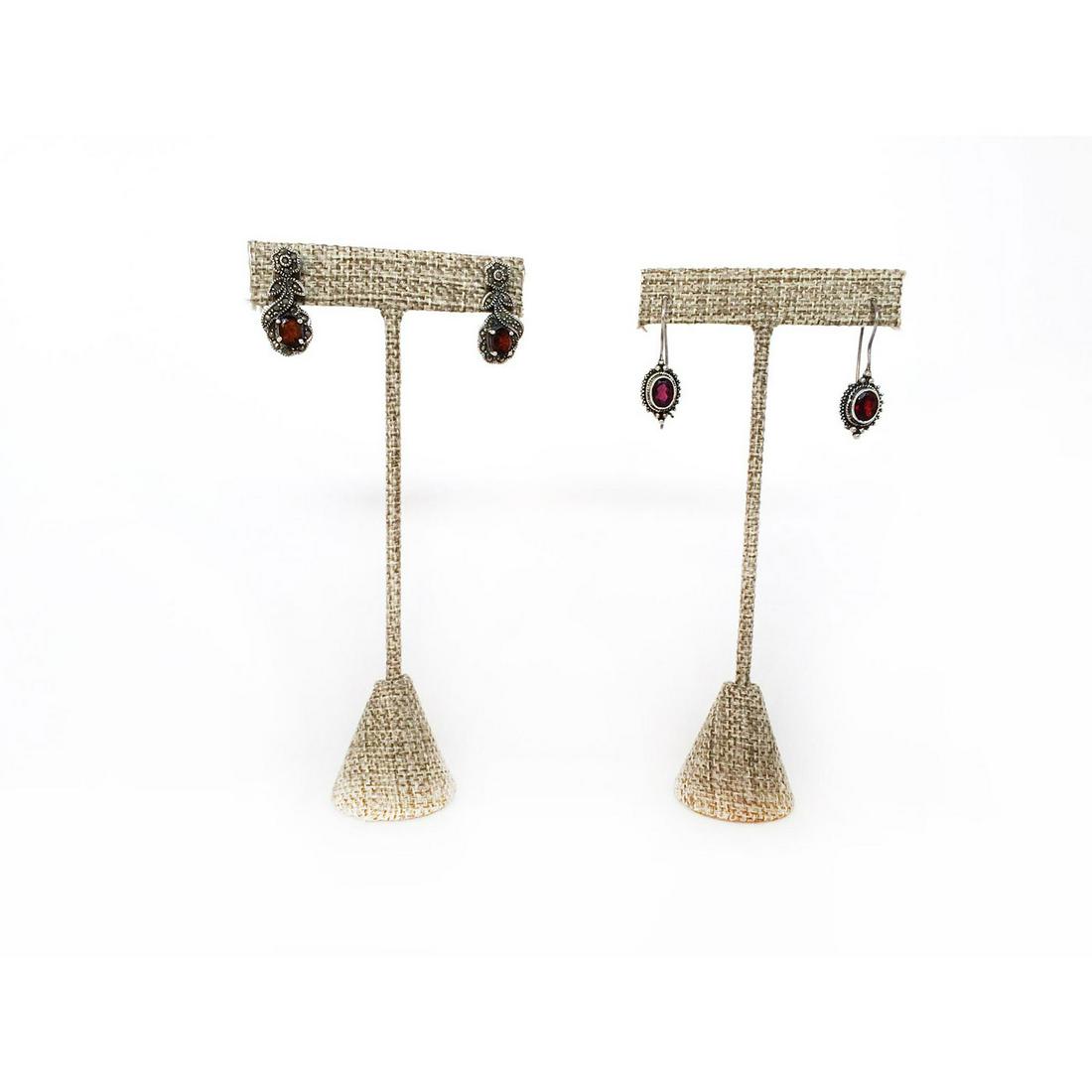 TWO PAIRS OF STERLING SILVER GARNET EARRINGS: One pair has marcasite design, the other has a simple elegant look. The longer pair is 1.25"L, stamped. The other pair is 1"L. Issued: 20th c. Dimensions: 1.25"L Provenance: David Farin Collection