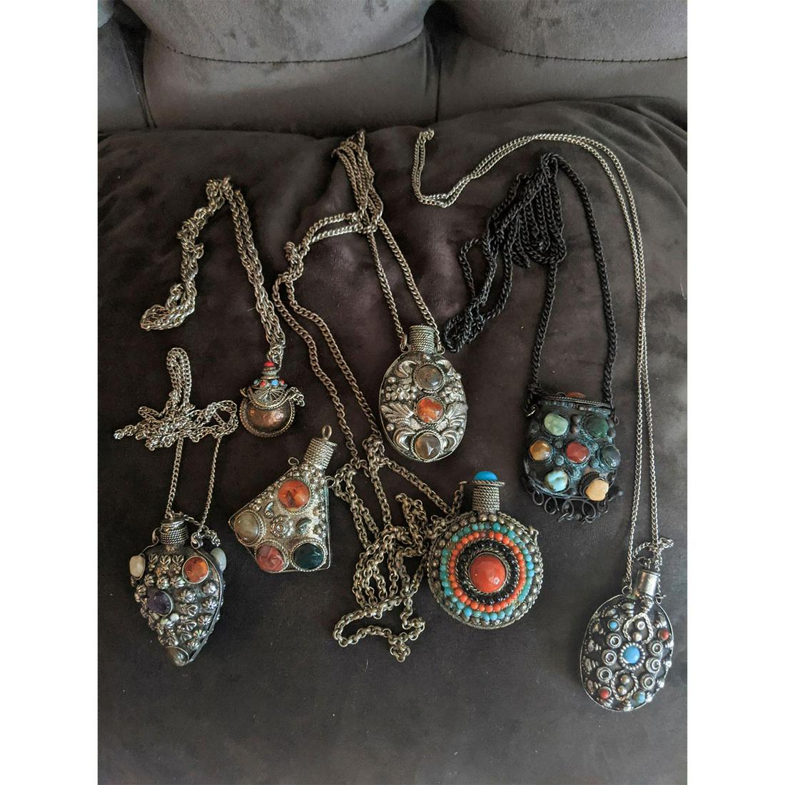 7 INDIAN / TIBETAN PERFUME BOTTLE PENDANT NECKLACES: Silver tone metal, w. inset stones. One pendant is missing necklaces chain. Issued: 20th c. Dimensions: 34"C, largest Country of Origin: India / China Provenance: David Farin Collection