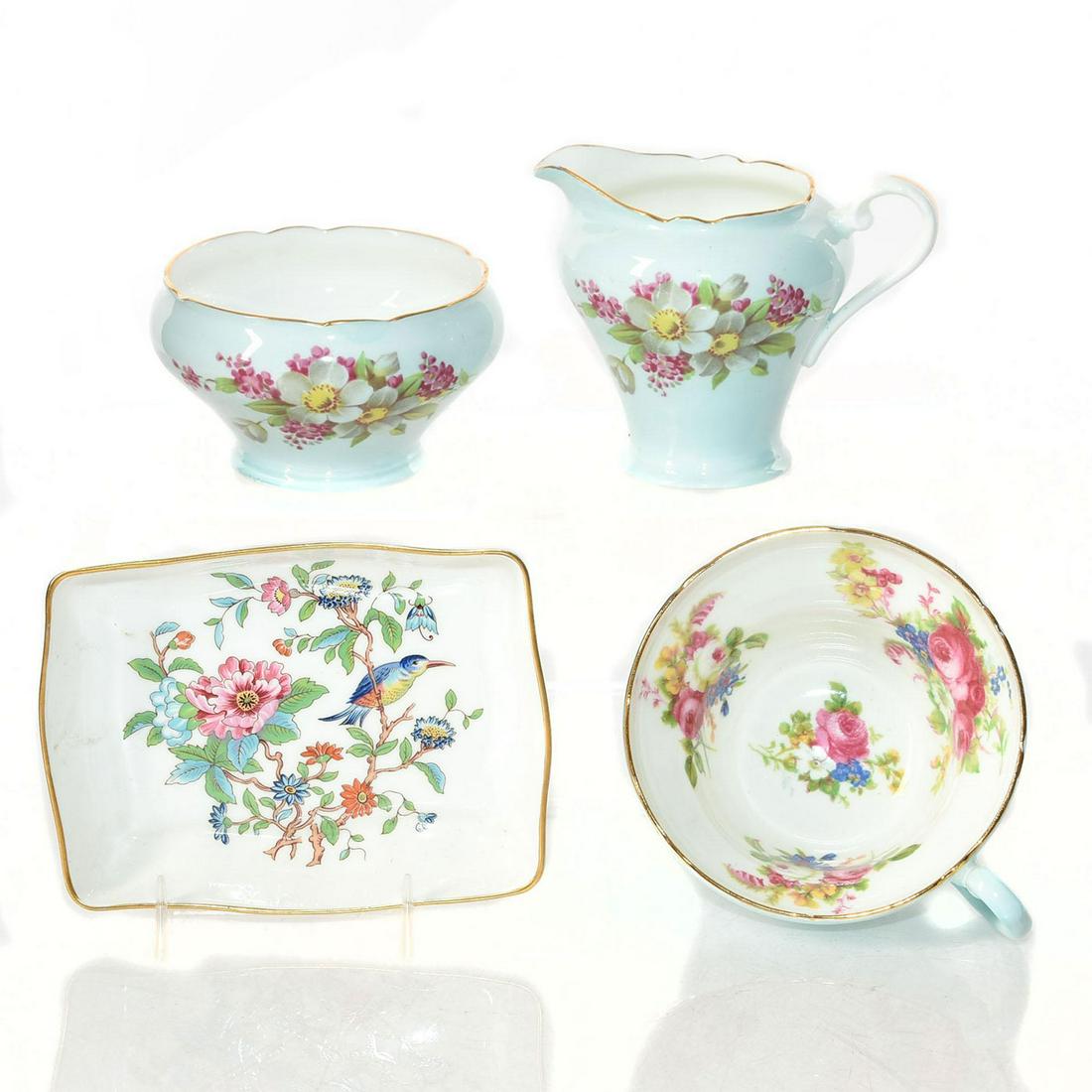 4 AYNSLEY & FOLEY TEA & VANITY PIECES, BONE CHINA: British ceramics decorated in profuse flora with gilt highlights. A group of four bone china British ceramics. One Foley Bone China teacup with scalloped rim, robins egg blue outer ground, and white g