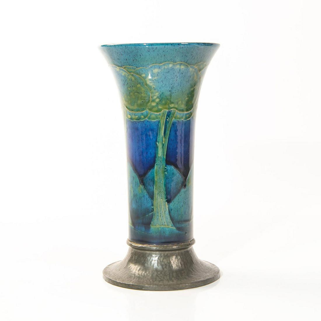MOORCROFT MOONLIT BLUE FOOTED TUDRIC VASE: Decorated with tubleined trees against blue ground. Raised on planished pewter base stamped TUDRIC, MADE IN ENGLAND, 01310. Produced for and retailed by Liberty & Co. in London. Artist: William Moorcr