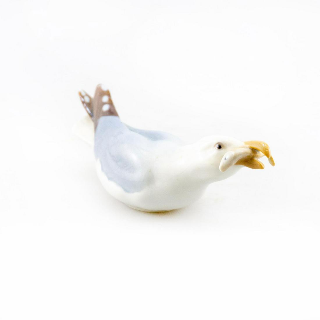 BING AND GRONDAHL ANIMAL FIGURE, SEAGULL 1808: Porcelain figure; seagull caught a fish. B and G backstamp. Issued: 20th c. Dimensions: 5.75"W Manufacturer: Bing and Grondahl Country of Origin: Denmark