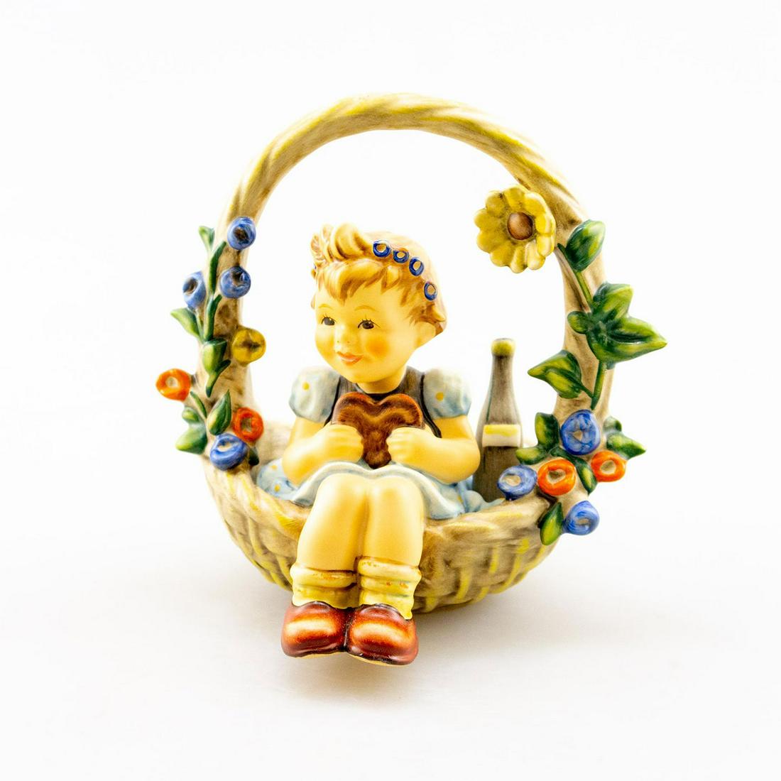 GOEBEL HUMMEL FIGURINE, BASKET OF GIFTS 618: Young girl in large basket. Hand crafted; hand painted. Goebel backstamp. Issued: 20th c. Dimensions: 5.25"H Manufacturer: Goebel Country of Origin: Germany