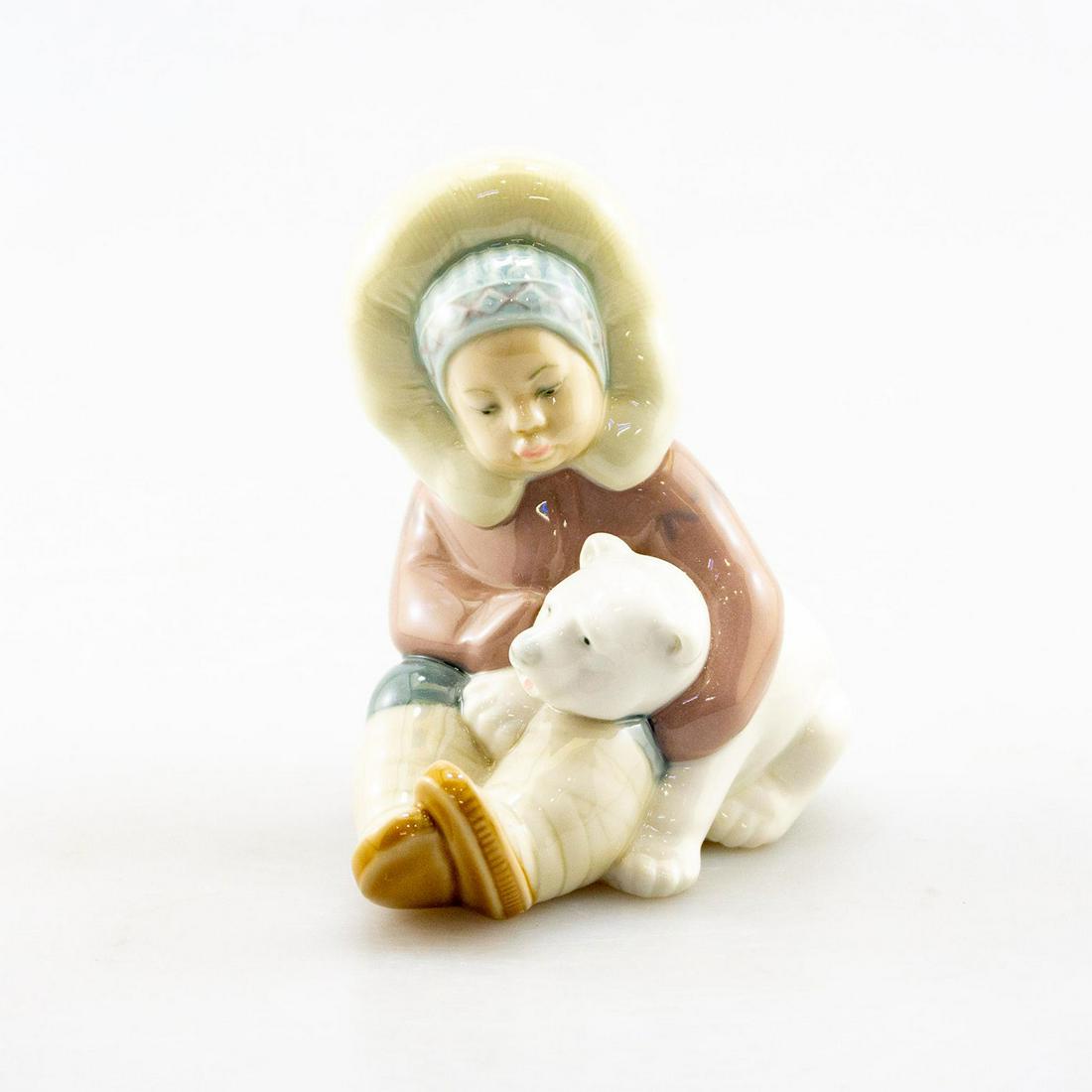 LLADRO DAISA FIGURINE, ESKIMO CHILD WITH POLAR BEAR: Porcelain; gloss finish. Seated young child hugging polar bear. Lladro backstamp. Issued: 20th c. Dimensions: 5.25"H Manufacturer: Lladro Country of Origin: Spain