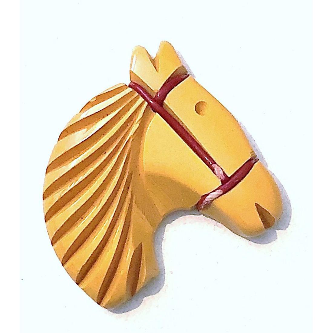 TWO 20TH CENTURY BAKELITE ANIMAL BUTTONS: 2 Butterscotch Bakelite buttons, one is a realistic shape. Included is a medium domed butterscotch Bakelite base with a reverse intaglio painted glass Scottie dog. The realistic shape is a large size 