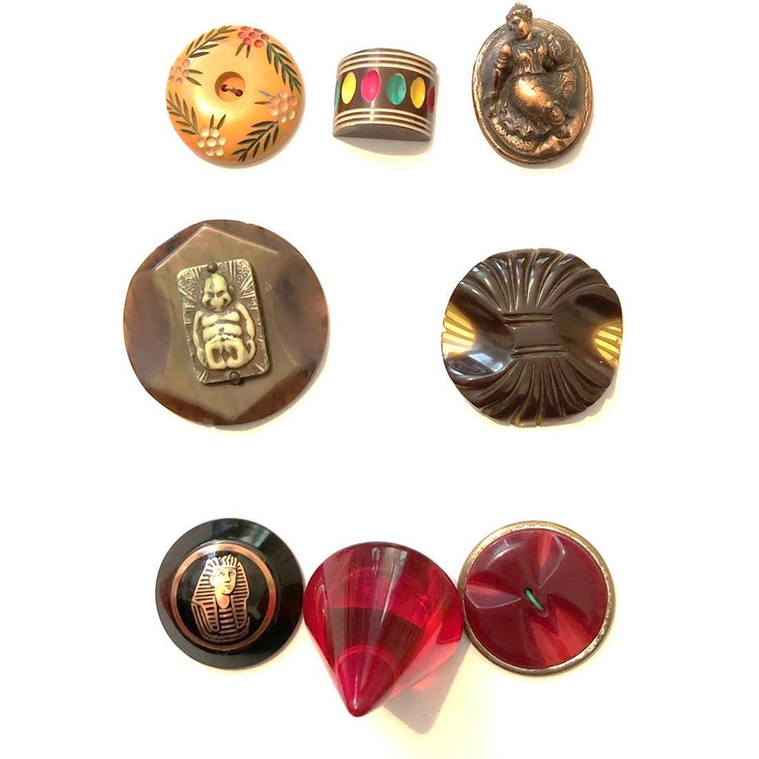 8 ASSORTED PLASTIC BAKELITE BUTTONS IN ASSORTED STYLES: 8 Large and medium assorted style plastic buttons. Included in this lot is a very cool large red thick and heavy plastic cone shaped button, a Bakelite base Egyptian motif, a high relief metalized cop