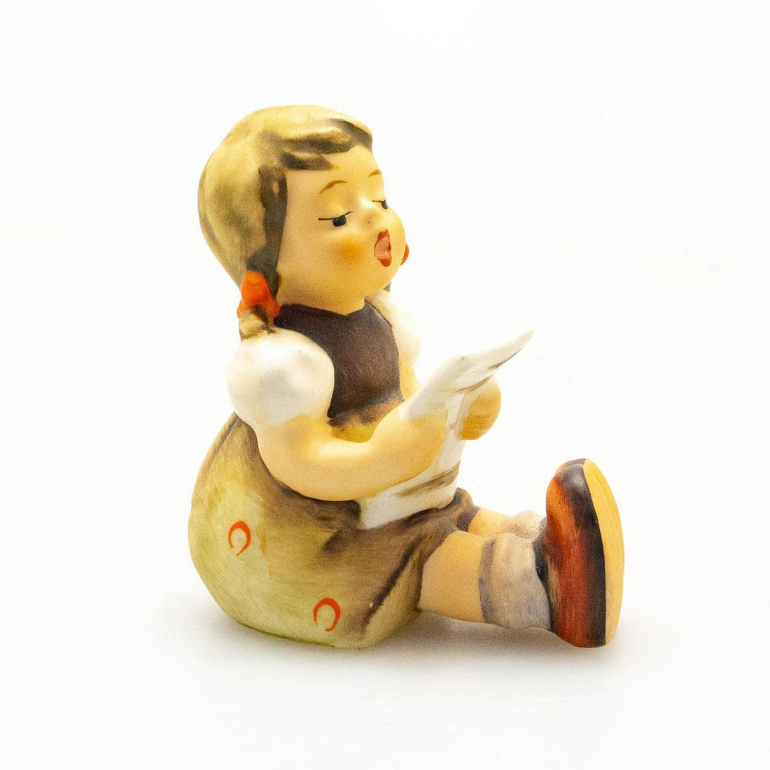 Goebel Hummel Figurine, Seated Girl with Music Sheet: Hand painted porcelain, matte finish. Impressed M.I. Hummel to backside. Goebel factory label to bottom base. Artist: M. I. Hummel Issued: 20th c. Dimensions: 5.75"H Manufacturer: Goebel Hummel Countr