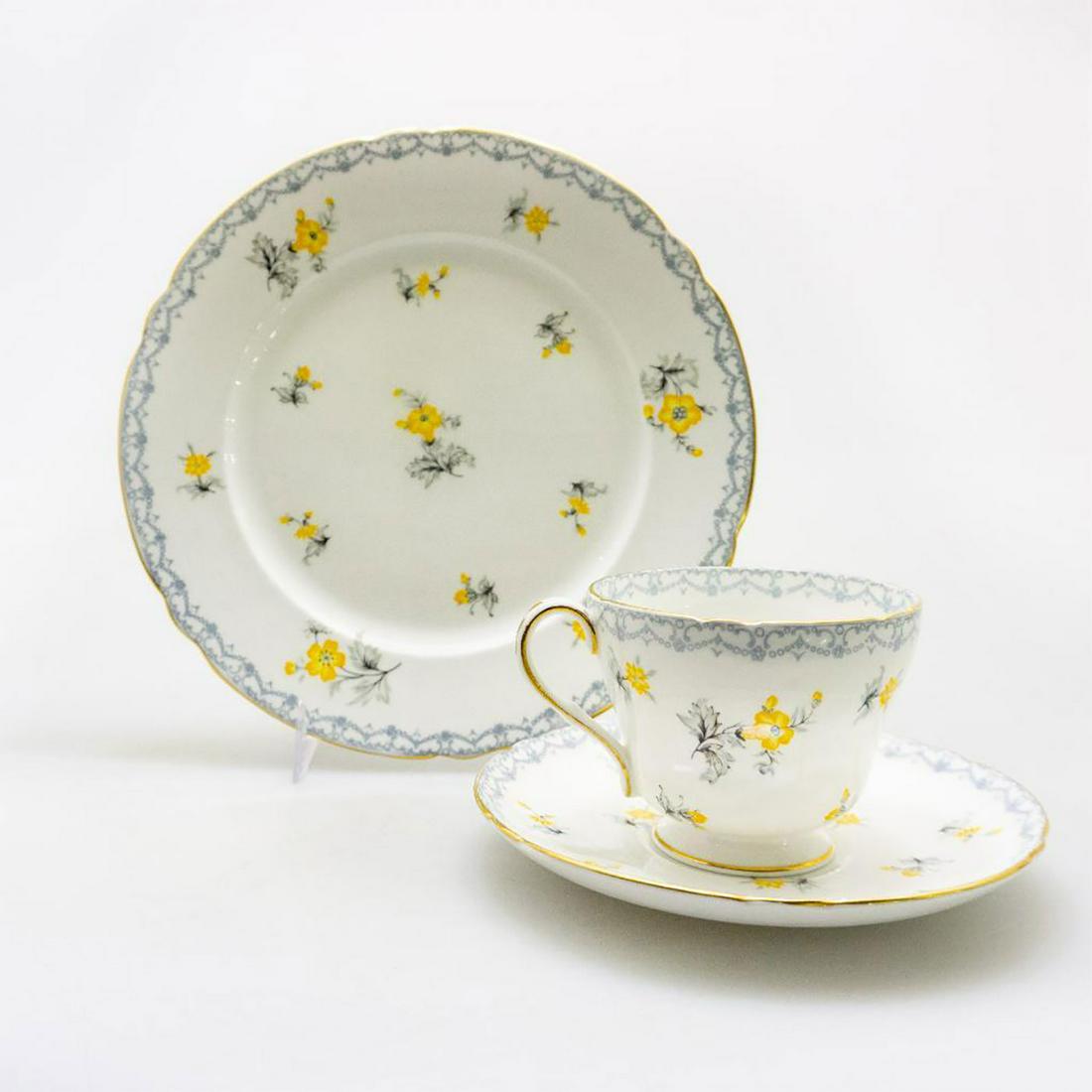 SHELLEY CHINA RICHMOND SHAPE TEA TRIO CHARM PATTERN: A delicate bone china teacup, saucer, and plate trio, with gray lace and gilt edges. Glazed cream with subdued yellow and gray flora, SHELLEY FINE BONE CHINA ENGLAND and CHARM backstamp. #ShelleyBoneC