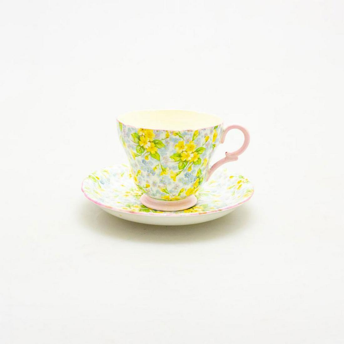 SHELLEY BONE CHINA ROCK GARDEN PRIMROSE TEACUP & SAUCER: A lovely vintage Art Deco bone china cup and saucer, with pink and yellow flora. Glazed cream with additional lavender and robins egg blue flora, pink trim. SHELLEY FINE BONE CHINA ENGLAND backstamp. 