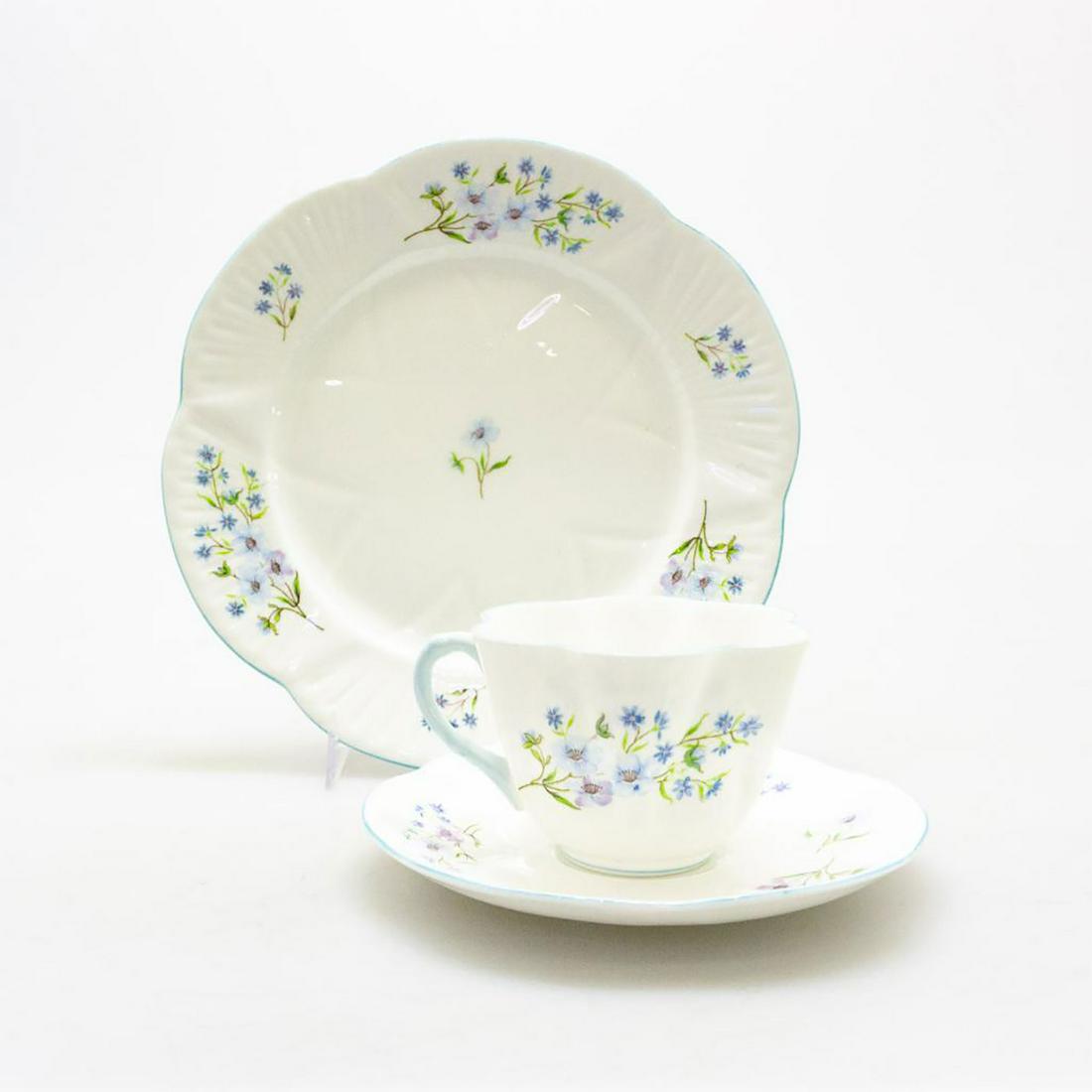 SHELLEY BONE CHINA DAINTY SHAPE TRIO, BLUE ROCK PATTERN: A delicate bone china teacup, saucer, and plate trio, with lavender and blue flora. Glazed cream and robins egg blue trim, SHELLEY FINE BONE CHINA ENGLAND and BLUE ROCK backstamp. #ShelleyBoneChina #B