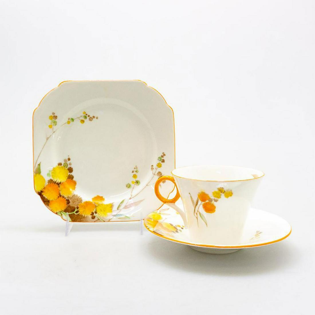 SHELLEY BONE CHINA ART DECO TEA TRIO, ACACIA PATTERN: An exemplary Regent style tea or demitasse group of cup, saucer, and plate decorated in striking fall colors. Glazed eggshell with orange, yellow, brown, green flora, and orange trim highlights. SHELL