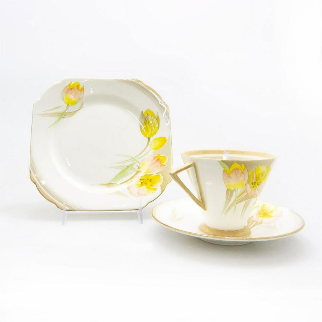 SHELLEY CHINA ART DECO EVE STYLE TRIO, TULIPS PATTERN: A beautiful group of tea or demitasse cup, saucer, and plate with pink, yellow flora. A beautiful Shelley trio in the Tulips pattern, designed in the Eve style with subtle yellow and pink flowers agai