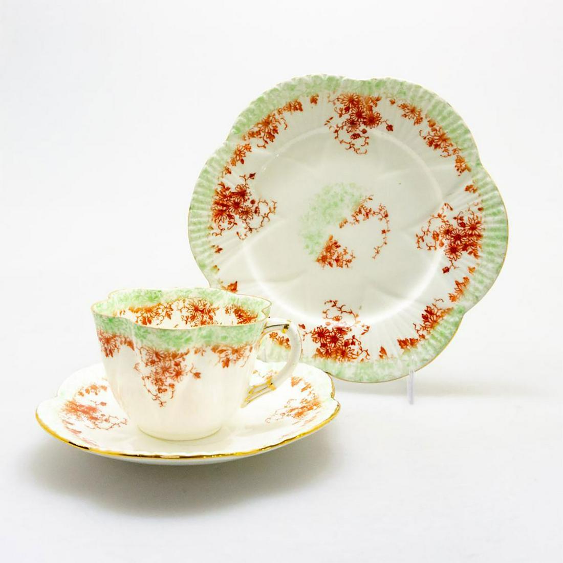 WILEMAN FOLEY CHINA TEA TRIO, TRAILING DAISY PATTERN: Rare Victorian pre-Shelley bone china cup, saucer, and plate trio, with russet and green flora. Glazed cream with gilding to scalloped rim. THE FOLEY ENGLAND backstamp, silver gilt 9059 pattern number