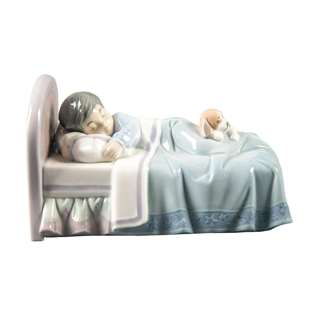 Lladro Figurine, Bedtime Buddies 010006541: Hand painted porcelain; gloss finish. Young boy asleep in his bed with his puppy. Lladro backstamp. w. box. Artist: Jose Javier Malavia Issued: 1998 - 2004 Dimensions: 6"W Manufacturer: Lladro Country