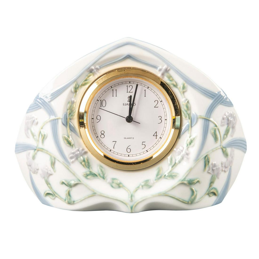 Lladro Mantel Quartz Clock, Segovia 01005655: Type 569, porcelain, high-relief floral motifs with blue ribbon pattern. Lladro backstamp. Not tested. Includes original box. Issued: 1988-1996 Dimensions: 7"W x 5.75"H Manufacturer: Lladro Country of