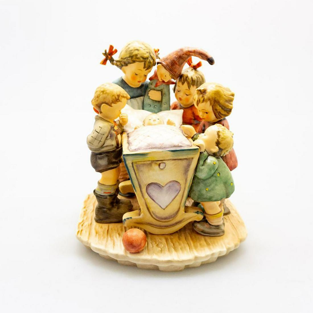 Goebel Hummel Figure, Rock A Bye 574: Ceramic; hand painted. 1994 Century Collection. Young children surrounding a rocking baby crib. Goebel backstamp. Issued: 1994 Dimensions: 8"H x 6"W Manufacturer: Goebel Country of Origin: Germany
