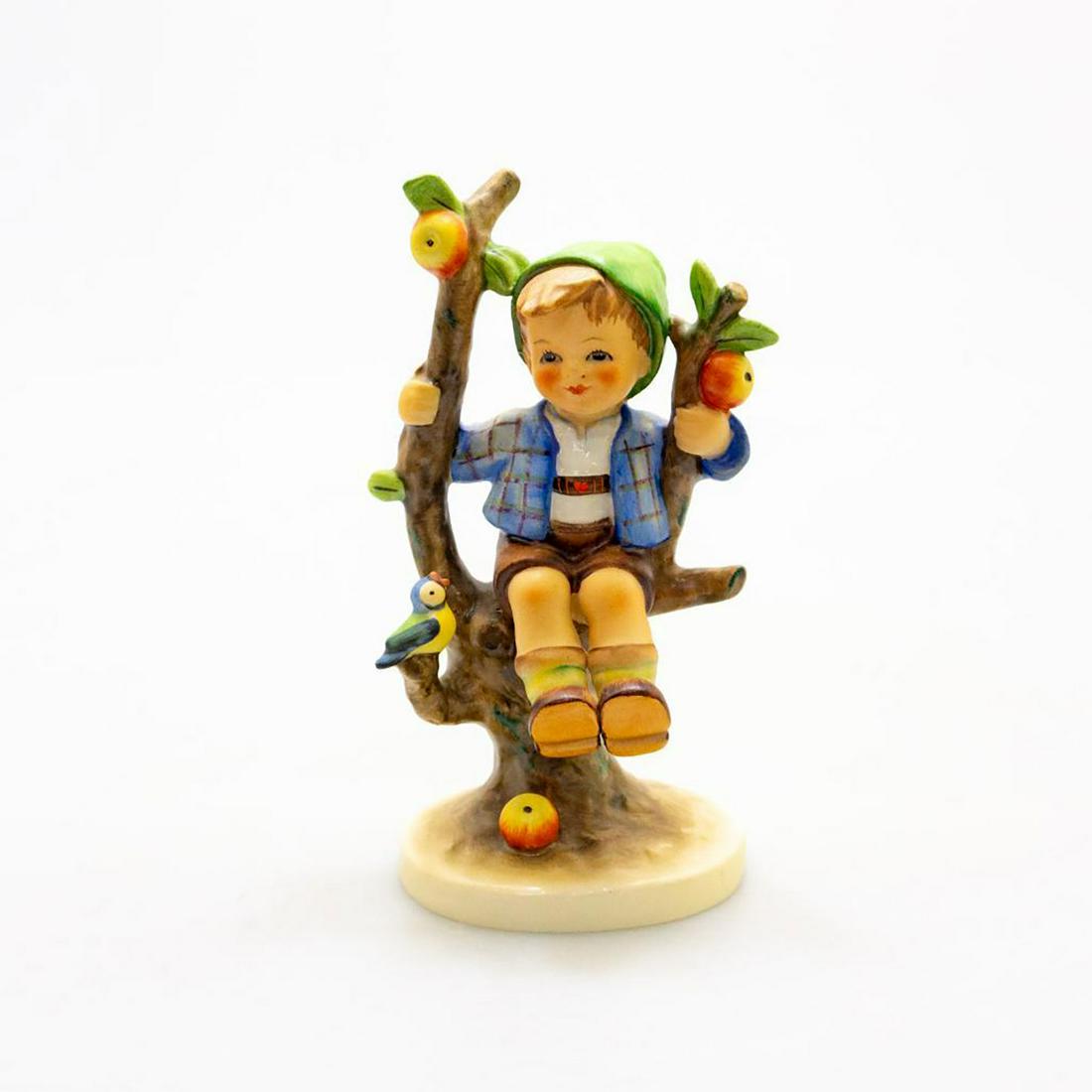 Goebel Hummel Figurine, Apple Tree Boy #142/1: A boy sits smiling in an apple tree. A singing bird accompanies him. Issued: 20th c. Dimensions: 6"H Manufacturer: Goebel Country of Origin: Germany