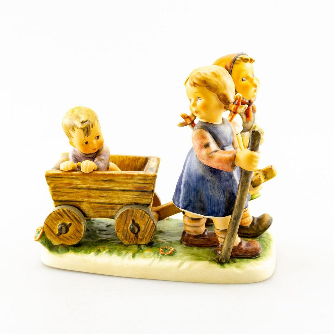 Goebel Hummel Figurine, Pleasant Journey #406: Two girls carry a small boy in a cart. Artist: Goebel Issued: 20th c. Dimensions: 7"H x 7.5"W Country of Origin: Germany