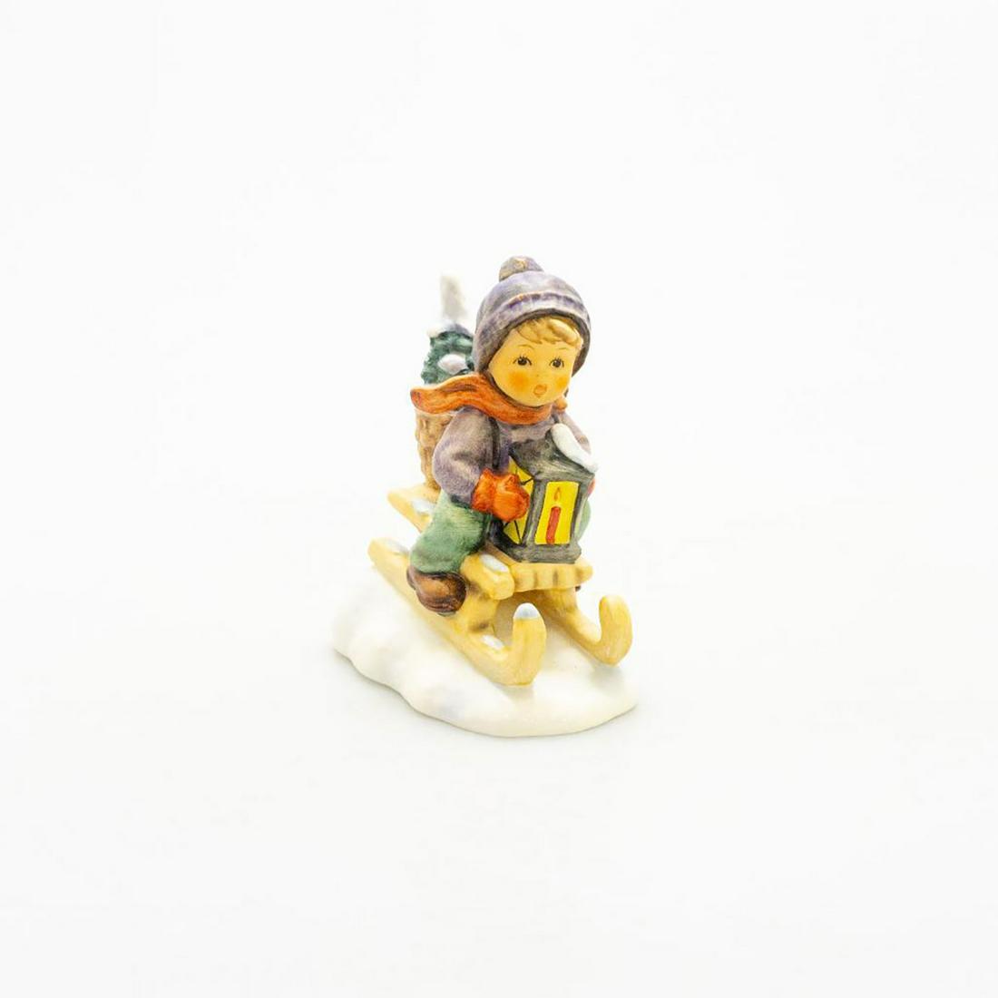 Goebel Hummel Figurine, Ride Into Christmas 396: Young boy in sled in the snow. Ceramic; handcrafted. Goebel backstamp. Issued: 20th c. Dimensions: 4.75"H Manufacturer: Goebel Country of Origin: Germany