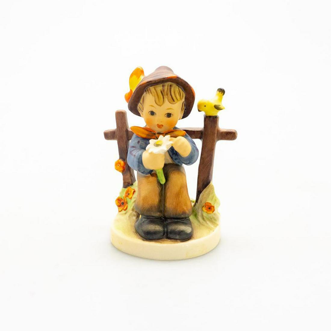 Goebel Hummel Figurine, She Loves Me Not 174: Ceramic; handcrafted; hand painted. Seated young boy with flower in hand. Goebel backstamp. Issued: 20th c. Dimensions: 4.5"H Manufacturer: Goebel Country of Origin: Germany