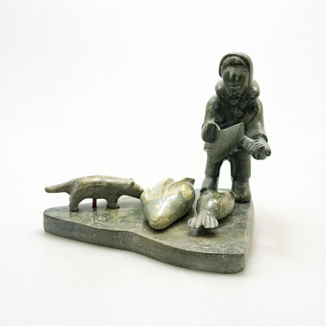 Inuit Tribal Carved Soapstone/Regional Stone Figural: An exemplary Inuit hand carving of a hunter, seals and dog. Artist numbered, signed. A whimsical study in hand carved soapstone of a seal hunter preparing his catch, presented on a stone base. Artist 