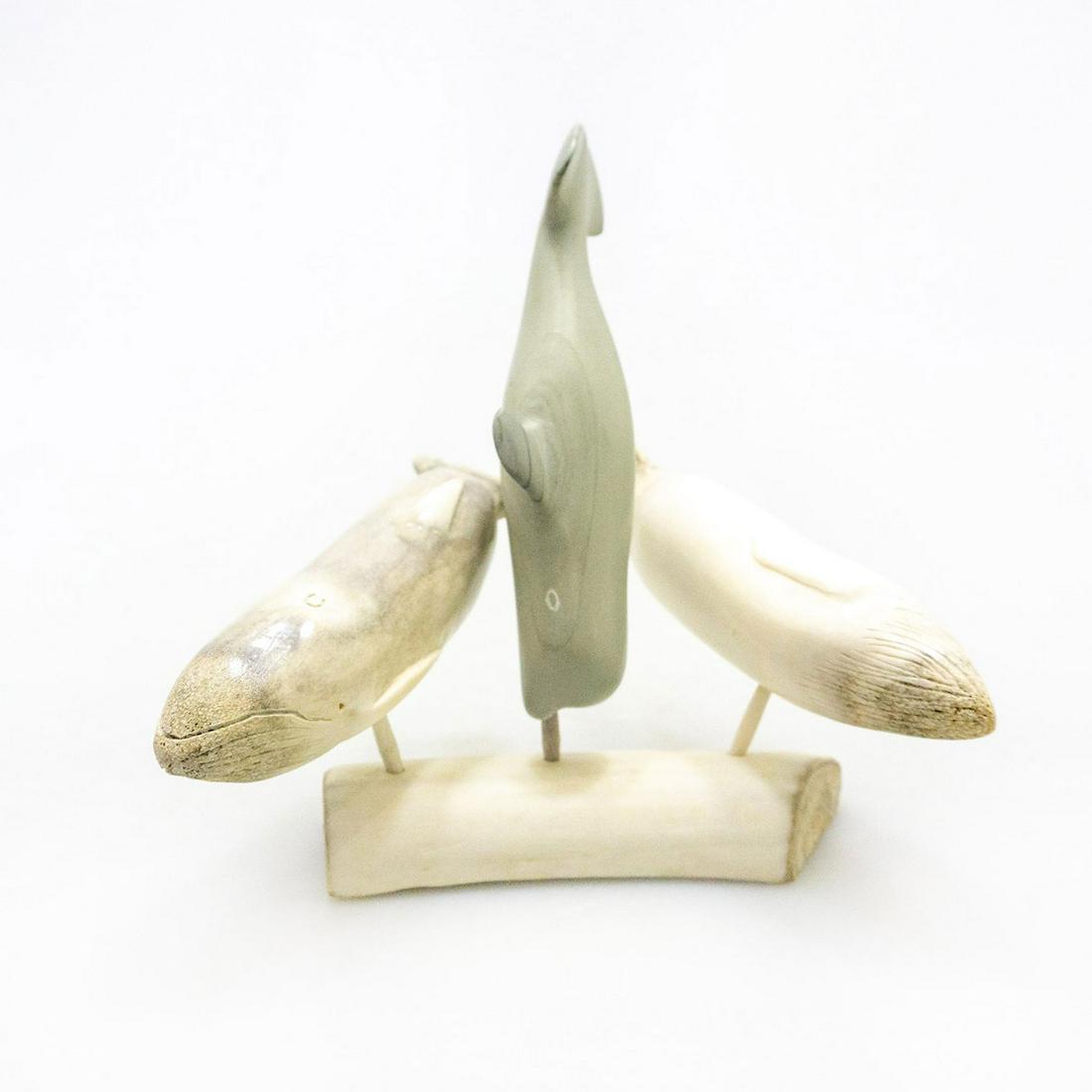 Inuit Tribal Soapstone/Regional Stone Figurine Group,: A striking figural group of three hand carved arctic whales, mounted on a caribou bone base. Made by Inuit artist Johnny Angutiqjuaq, three polished soapstone whale sculptures, displayed on a hand car
