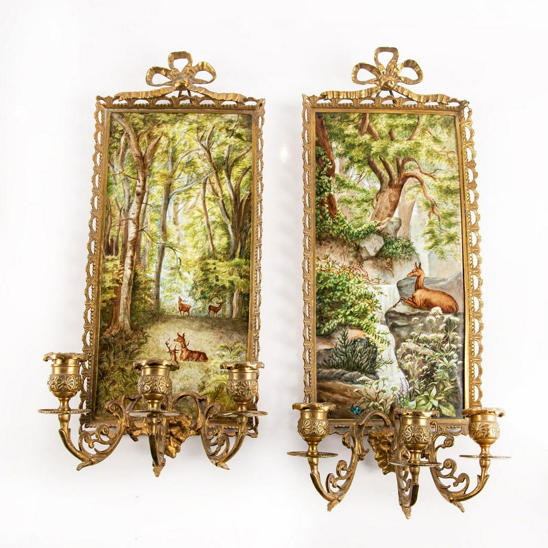 Pair Of Porcelain Plaque Wall Sconces: Handpainted porcelain; deer in landscape. Plaques housed in rectangular gilt candle holder frame. Signed and dated by artist. Issued: 1887 Dimensions: 19.75"H x 7.75"W Country of Origin: Germany