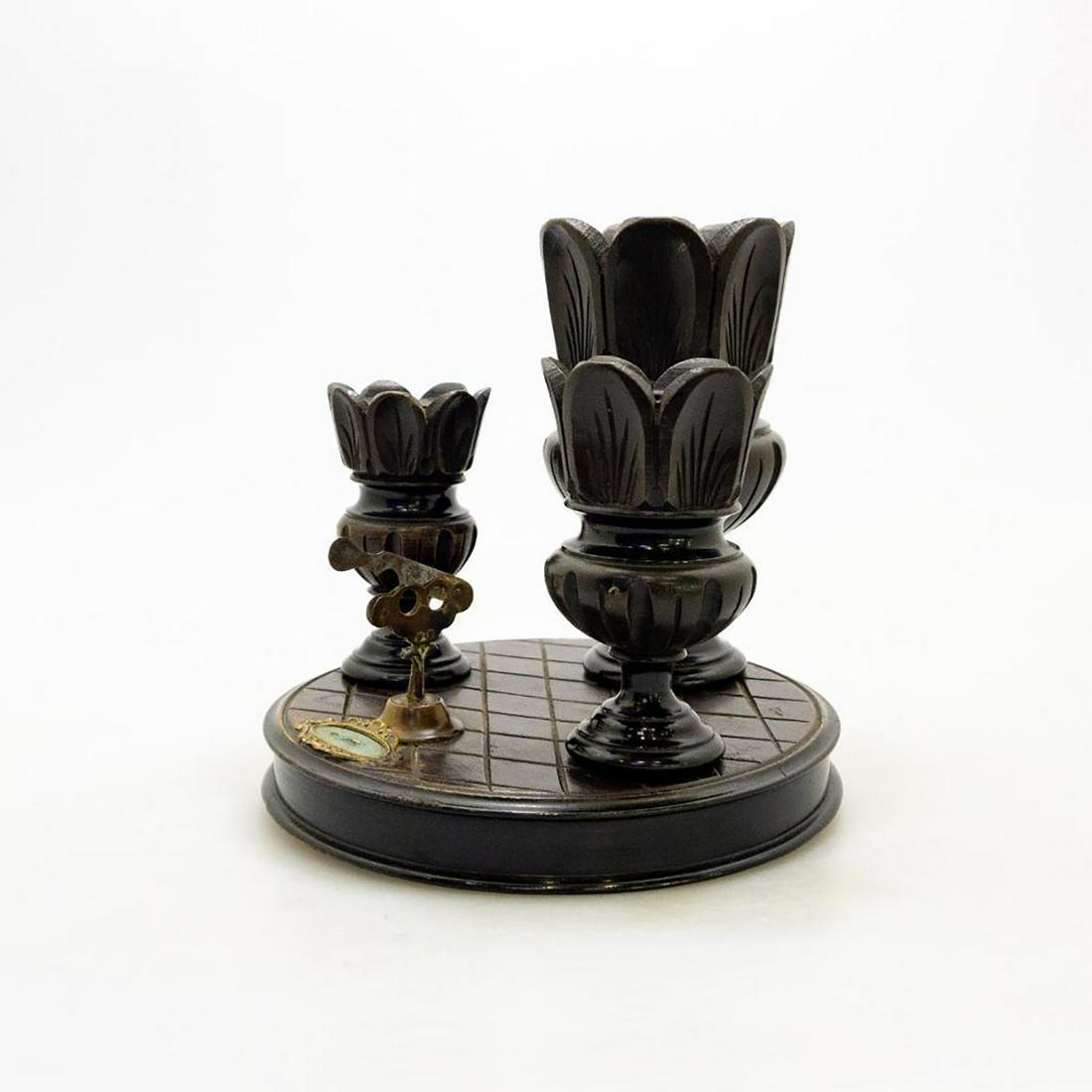 Ebonized Cigar Stand With Cigar Cutter: This is an Ebonized cigar stand with cigar cutter. Included are 3 upright containers-one each for cigars, cigarettes and matches. The ornate brass cutter is at the front of the stand and includes a ma