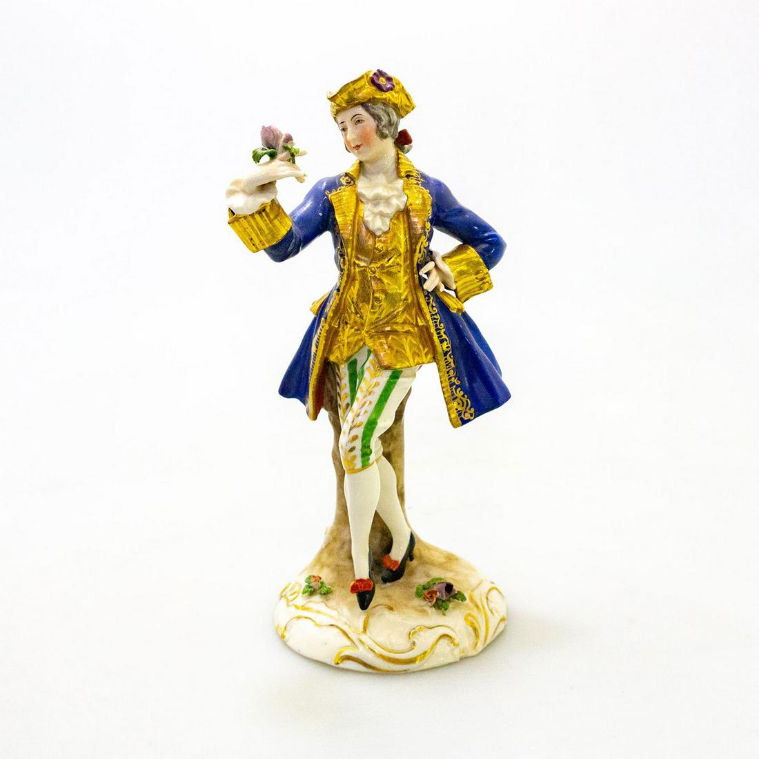 Capodimonte Porcelain Figurine, Purple Flower: Hand painted in cobalt blue, heavily gilded of a colonial lad holding a purple flower. Capodimonte mark to backside. Impressed 1182 under blue mark. Small hairline crack to top base around flowers. Sm