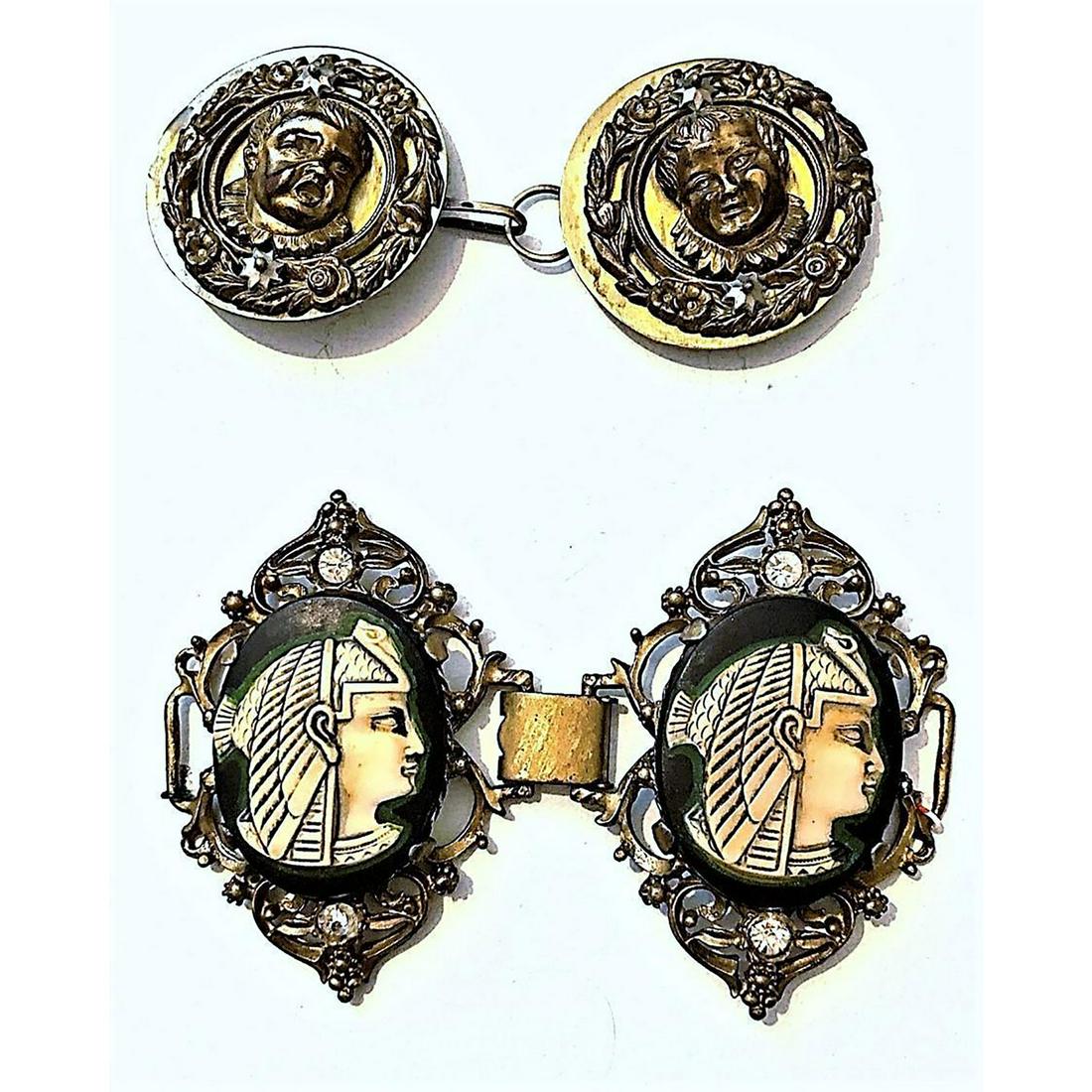A Pair Of Pictorial Division 1 Buckles: 2 Two piece large metal and OME buckles. One example in this lot has an Egyptian early celluloid in metal, the other is a brass escutcheons of baby heads on steel. Issued: DIVISION 1=PRE 1918 AND DIVI
