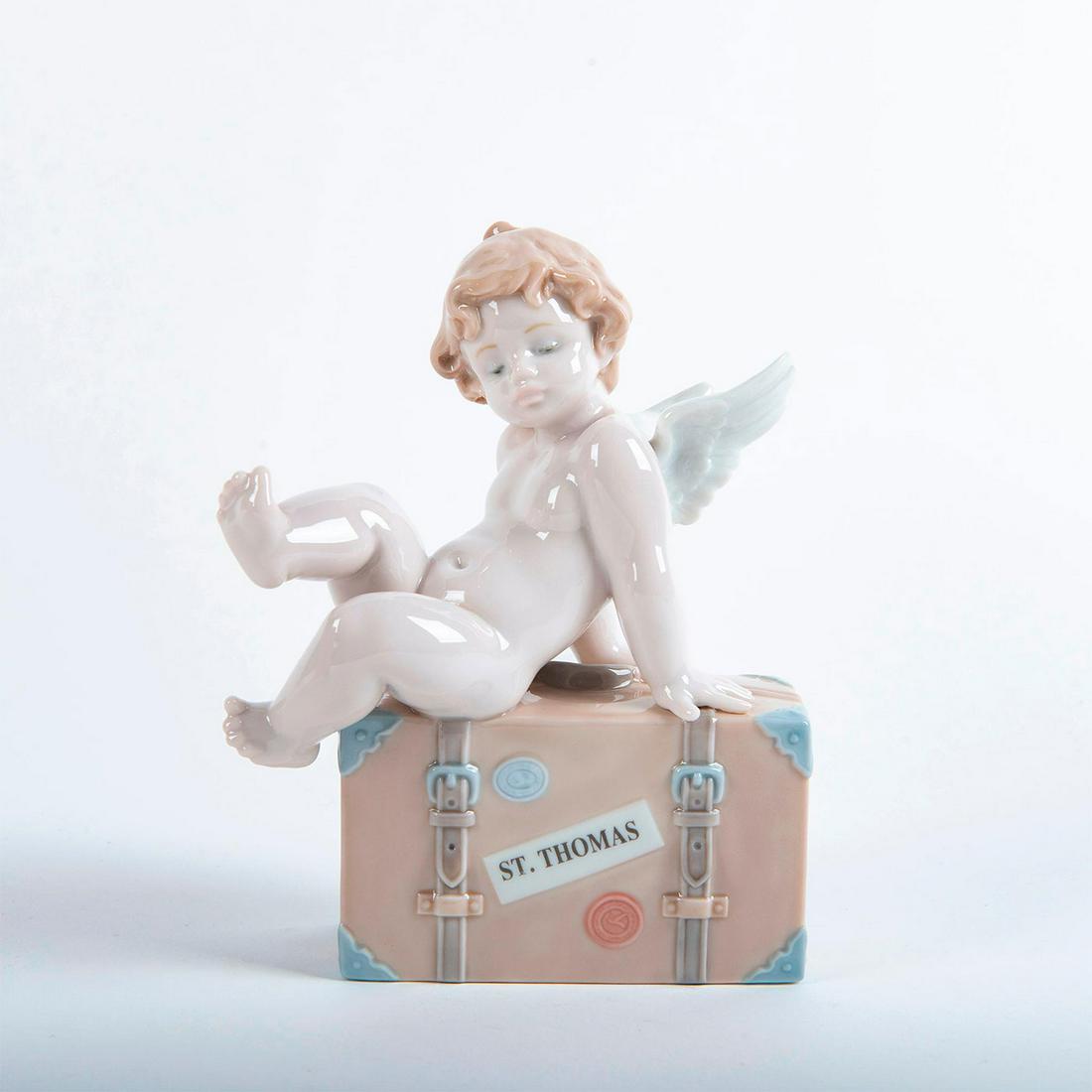 Lladro Figurine, Travel The World St. Thomas 01007333: Glossy porcelain; modeled as an angel sitting on a luggage lableled St. Thomas. Lladro backstamp. Does not include original box. Artist: Antonio Ramos Issued: 2003 Dimensions: 6.75"H Manufacturer: Lla