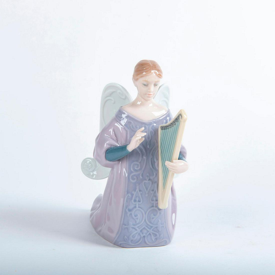 Lladro Porcelain Figurine, Harp Cantata Angel 01008178: Glossy porcelain figurine modeled as an angel in a soft pink gown playing a harp. Lladro backstamp. Does not include original box. Artist: Miguel Angel Santaeulalia Issued: 2005 Dimensions: 6"H Manufa