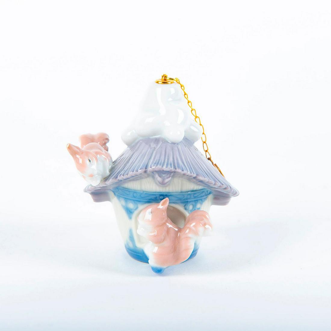 Lladro Christmas Ornament, Our Winter Home 01006519: Glossy porcelain; modeled as a house with two squirrels. Lladro backstamp. Includes original box. Artist: Design and Decoration Department Issued: 1999 Dimensions: 3"H Manufacturer: Lladro Country of 