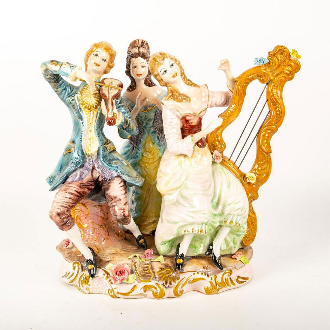 Large Capodimonte Style Figure Group, Musical Trio: Hand painted; polychrome; gilt accents. Includes harpist and violinists. Intricate floral detail on base and harp. Capodimonte backstamp. Issued: 20th c. Dimensions: 19.5"W x 18"H Country of Origin: I